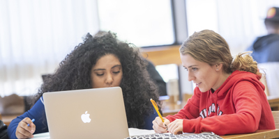 NIU students working together in the library.